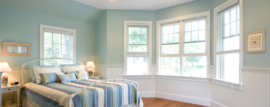 Teal bedroom with large bay windows